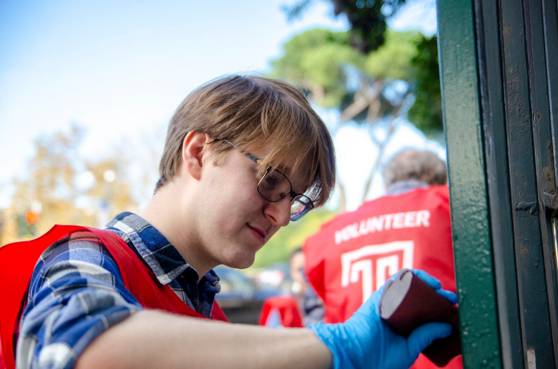 student volunteer painting gate