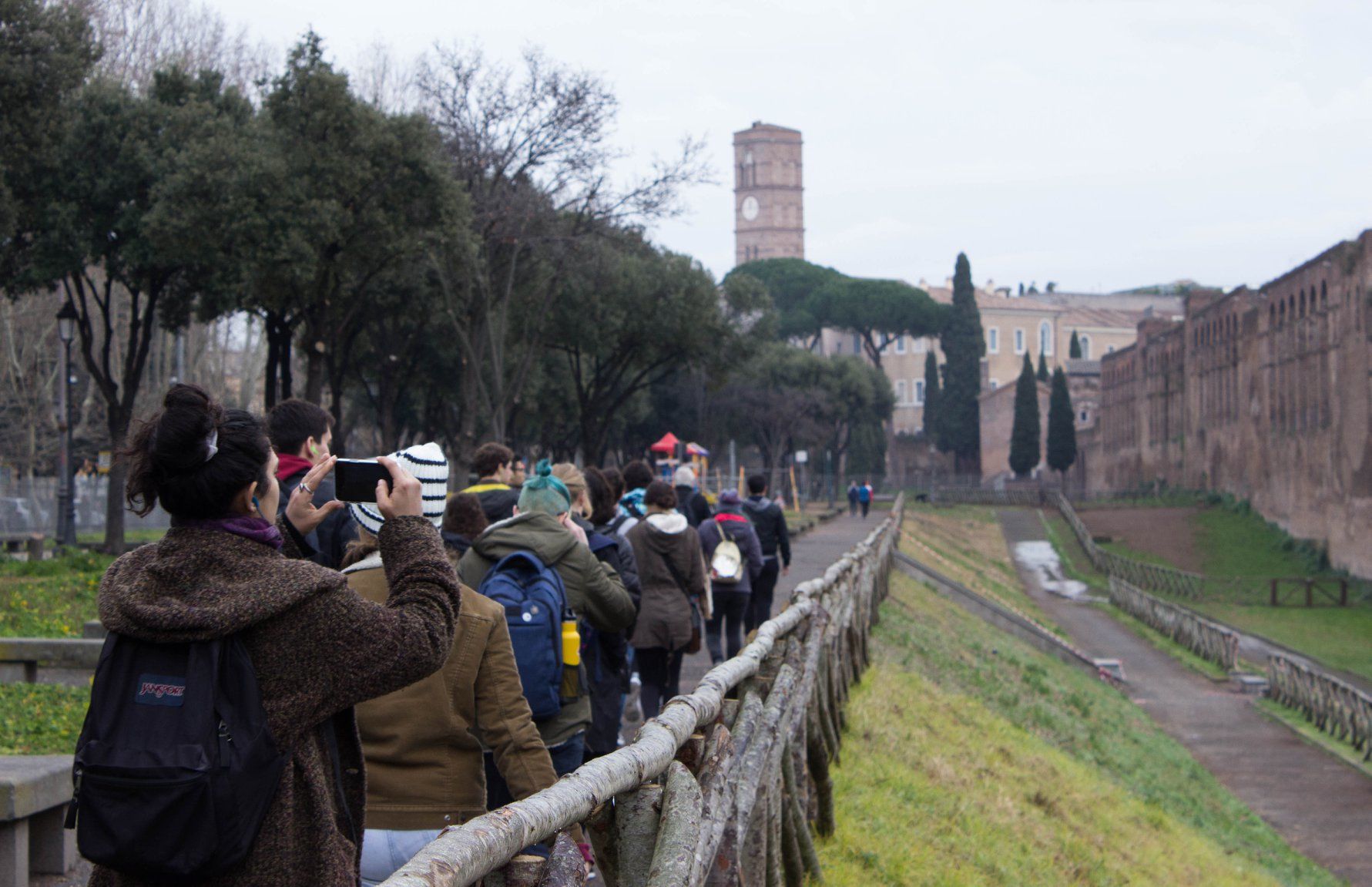 Group of students walking along Aurelian wall of Rome