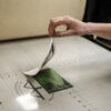 Hand picking up print from printmaking etching