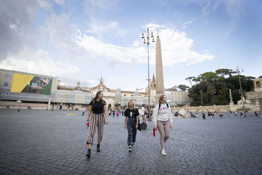 Three female students walking in Piazza del Popolo