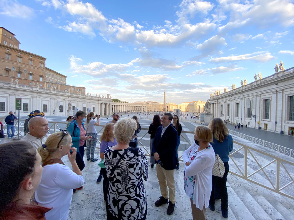 Group of adults standing in circle with St. Peter's in the background