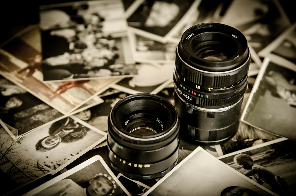 two camera lens surrounded by photographs