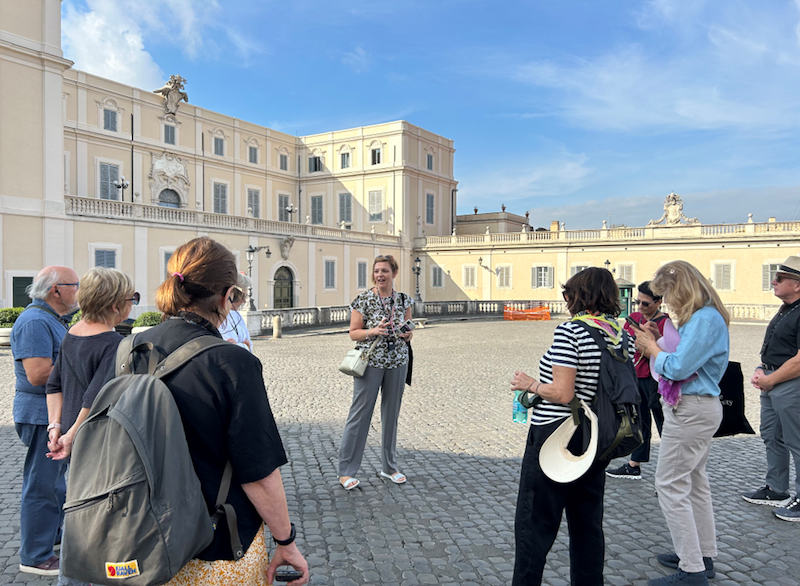 Group of adults standing in a Roman piazza