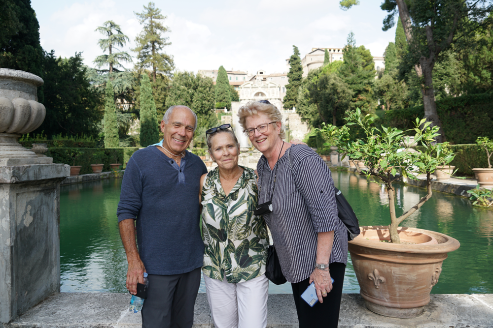 Three people smiling in front of fountains in Tivoli